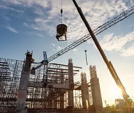 Construction site with cranes at sunset